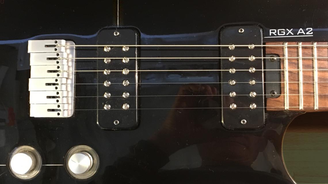 Close up of the RGX A2 showing the name, two pickups bridge and two controls